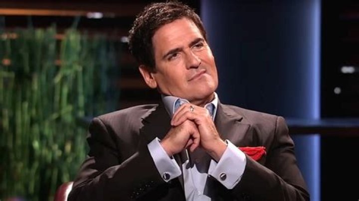 Mark Cuban is listening to and watching a pitch on Shark Tank.