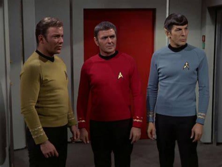 Scotty, Spock, and Kirk looking at a dog with a horn on its head