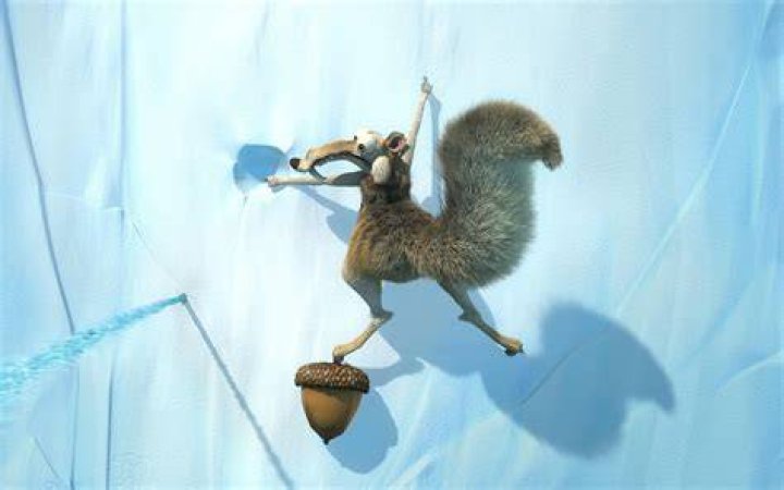 Scrat is holding up an acorn.
