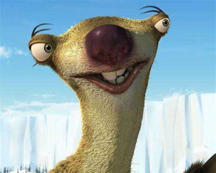 Sid from Ice Age is looking at a Christmas tree.